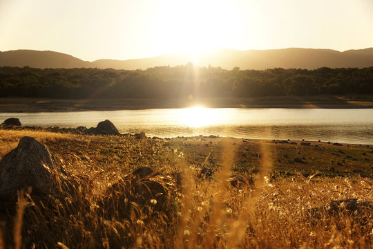 Picturesque view of lake with countryside route, fir forest and hills in Valmayor Lake Spain