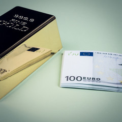 Euro cash and gold bar on a green background. Banknotes. Money. Bill. Ingot. Bullion.