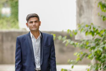 Portrait of a young Indian successful businessman wearing suit and Spectacles