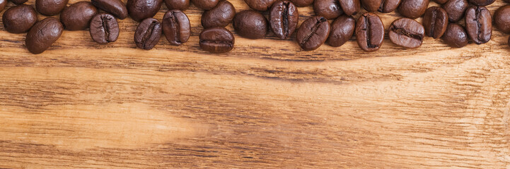 Coffee bean. The background of roasted coffee beans is brown on wooden boards. layout. Flat lay.