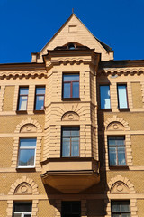 Facade of beautiful old yellow house with bay window in downtown of Saint Petersburg Russia with blue sky on the background