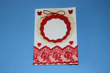 Valentines day greeting card decorated with openwork red cloth and lace tied with a bow and beads in the shape of butterflies