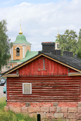 Fototapeta na wymiar Old wooden house in Finland with church on the background