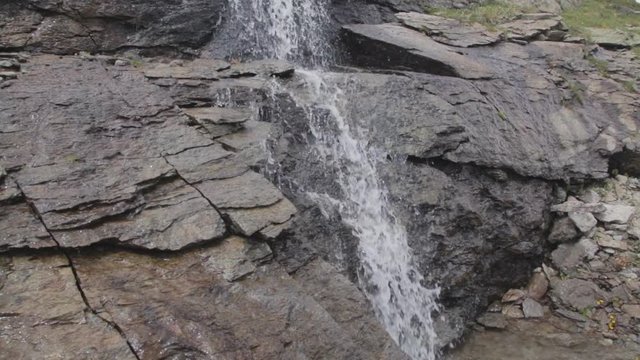 A hand held shot of a small mountain river pouring through the rocks at the border of Italy and Switzerland, Forcola di Livigno, Livigno Pass