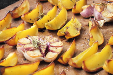 Oven baked potatoes and garlic on a frying pan with spices and olive or sunflower oil.