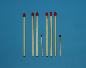 wooden matches a long match with a red tip and a short match with a black tip lie in a row