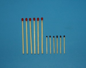 wooden matches a long match with a red tip and a short match with a black tip lie in a row