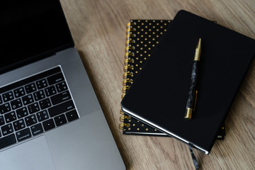 2 notebook with pen and computer on wooden desk
