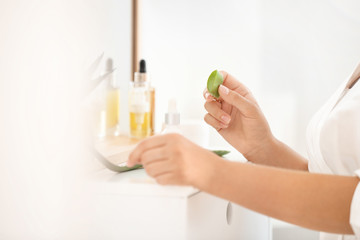 Beautiful young woman using aloe vera at home, closeup