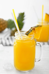 Mason jar of tasty pineapple juice on white table