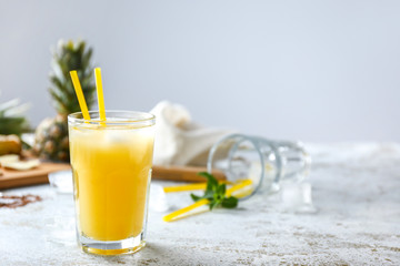 Glass of tasty pineapple juice on light table