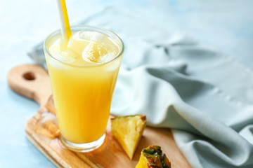 Glass of tasty pineapple juice on table