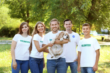 Volunteers with cute dog outdoors