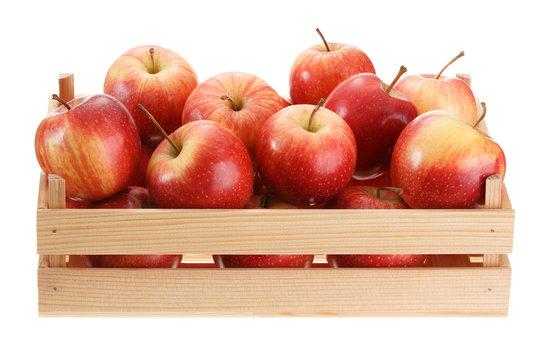 Crop of ripe red apples in a wooden crate. Isolated on white background.
