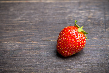 Ripe and juicy strawberries on the dark rustic background. Selective focus. Shallow depth of field.