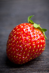 Ripe and juicy strawberries on the dark rustic background. Selective focus. Shallow depth of field.