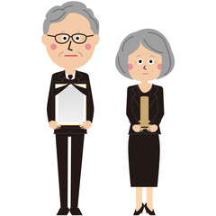 ポップな黒いスーツを着たシニアの男女がお出迎え　笑顔無し