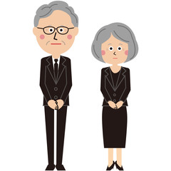 ポップな黒いスーツを着たシニア男女が遺影と位牌を持って立っている