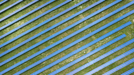 aerial view of solar panels on green lawn. drone shot, bird's eye