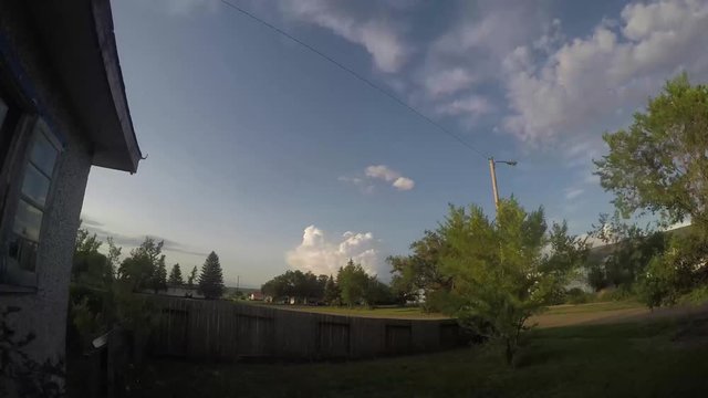 TIME LAPSE - Clouds in a blue sky skying over a small town in Alberta Canada.