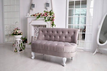 Interior of a living room with a sofa with flowers. Location for the photo shoot in pastel colours