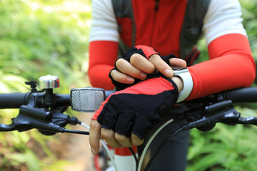 Riding on summer hill,  set the smartwatch while riding bike in forest on sunny day