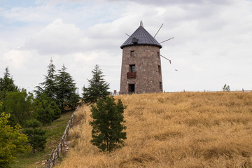 Fototapeta premium An Old Wooden Windmill in the Field