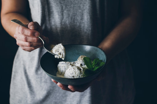 Midsection of woman holding bowl with stracciatella ice cream balls