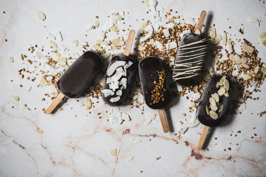Overhead view of chocolate popsicles on marble table