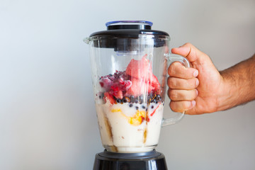 A blender filled with fresh whole fruits for making a smoothie or juice. Healthy eating concept. - 278878496