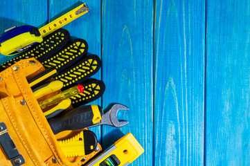 Necessary set of tools in the bag for plumbers on a blue wooden background.