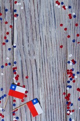 September 18, happy independence day of Chile. memorial day for independence. the concept of patriotism. mini flags with confetti on white wooden background