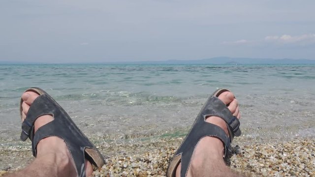 Enjoying in the sea men legs on beach