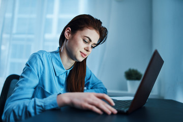 young woman working on laptop computer at home