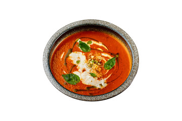 Plate of tomato gaspacho soup served with nuts isolated at white background.