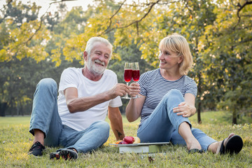 Couple seniors sipping wine fruity together with happy face.