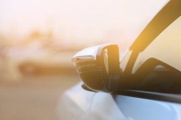 Fold the car side mirror with backdrop of the sunlight.