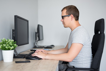 young handsome man using computer in office or home