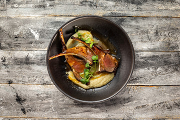 Pan of grilled lamb served with mashed potatoes at wooden rustic table background. © Mayatnikstudio