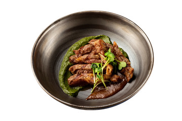 Pan of baked duck breast served with sauces isolated at white background.