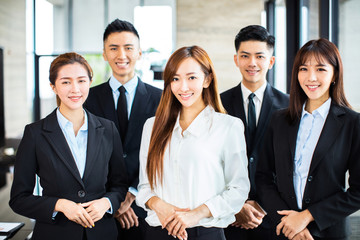 confident asian business team stands in office