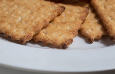 Macro photo of brown dietary low-calorie crispy cereal cracker with sesame dressing close-up on a white background