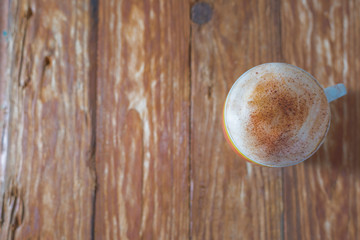 Delicious brown cappuccino an Italian Style beverages on a wood table.