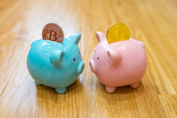 Silver and golden bitcoin inserted in ceramic piggybanks