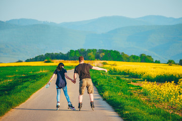 Roller skates in nature. Man and woman train together. Active time in nature