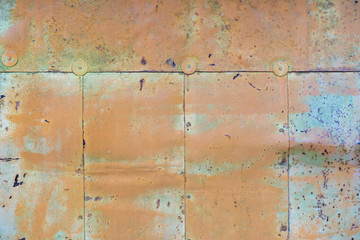 orange paint peeling off old metal strips. Old Metallic patchwork orange. Metal panels are peeling off paint. old metal sheets