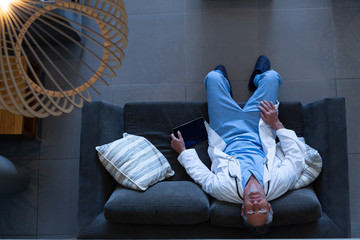 Male doctor relaxing on sofa in the lobby in hospital