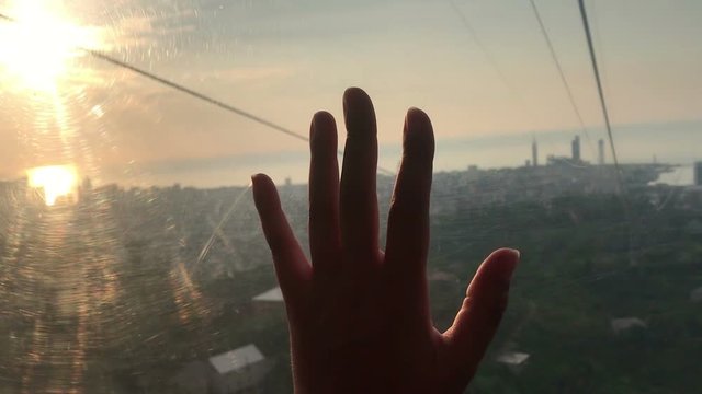 hand touching glass inside funicular cabin, on sunset, tactile sensations, travel concept