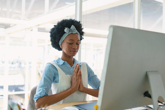 Female graphic designer performing yoga at desk - Powered by Adobe