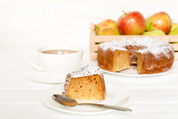 Morning still life with cake with icing served tea and raw apples on white table. Selected focus